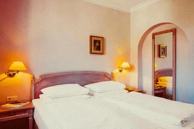 a bedroom with a large white bed and a mirror at Amadeus Ora & Amore in Caldaro
