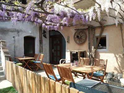 a table and chairs on a patio with purple flowers at Haus Möltner - Apartment 
