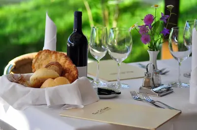 a table with a basket of bread and a bottle of wine at Bad St Isidor in Bolzano