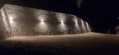 a dark room with a stone wall with lights at Bad St Isidor in Bolzano