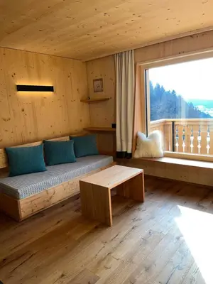 a living room with a couch and a large window at Bio Felderhof in Villa Ottone
