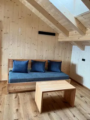 a bed with blue pillows in a wooden room at Bio Felderhof in Villa Ottone