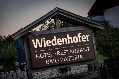 a sign for a hotel restaurant bar and pizza at Hotel Wiedenhofer in Terento