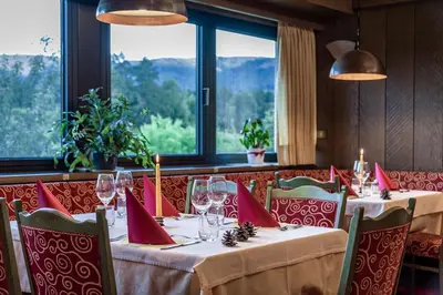 a table with red napkins and wine glasses in a restaurant at Hotel Wiedenhofer in Terento