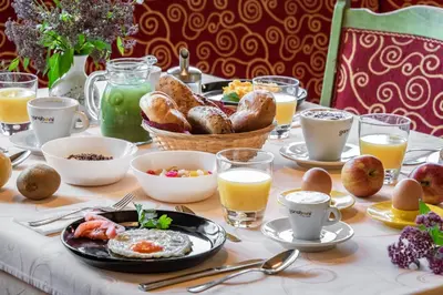 a breakfast table with eggs and bread and glasses of orange juice at Hotel Wiedenhofer in Terento
