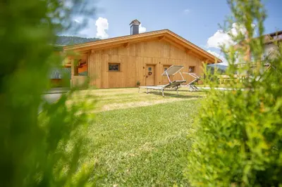 a wooden house with a bench in the yard at Ditterhof in Tesido