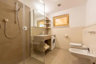 a bathroom with a shower and a toilet and a sink at Ditterhof in Tesido