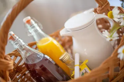 a basket with a bottle of oil and a drink at Ditterhof in Tesido