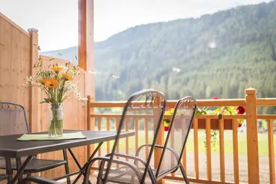 a table and chairs on a balcony with a view of a mountain at Ditterhof in Tesido