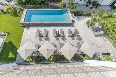 an overhead view of a swimming pool with lounge chairs and a swimming pool at Marchegg Apartments in Naturno