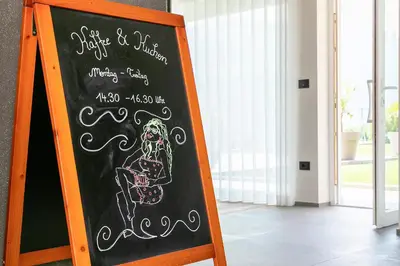 a chalkboard sign with a drawing of a skeleton on it at Appartement-Hotel Beatenhof in Tirolo