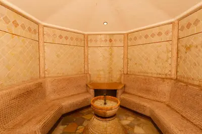 a bathroom with a toilet in the corner of a room at Hotel Amaten in Brunico