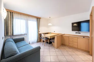 a living room with a couch and a dining room at Ciasa Mascotte in San Vigilio Di Marebbe