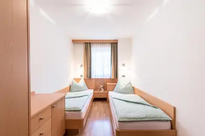 a hospital room with two beds and a window at Ciasa Mascotte in San Vigilio Di Marebbe