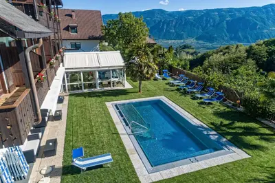 an image of a swimming pool on the lawn of a house at Hotel St. Justina Hof in Appiano sulla Strada del Vino