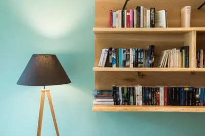 a book shelf filled with books next to a lamp at Bio & BikeHotel Steineggerhof in Collepietra