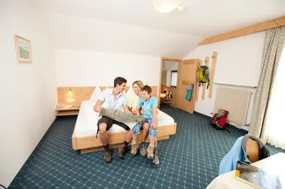 a man and a boy are sitting on a bed at Bio & BikeHotel Steineggerhof in Collepietra