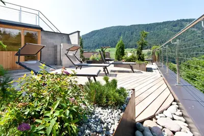 a deck with benches and plants on a house at Bio & BikeHotel Steineggerhof in Collepietra
