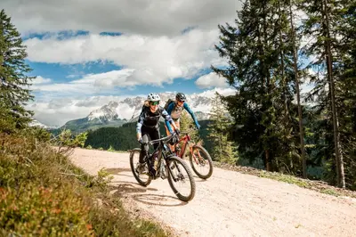 two people riding bikes on a dirt road at Bio & BikeHotel Steineggerhof in Collepietra