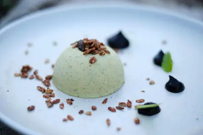 a dessert on a white plate with nuts on it at Bio & BikeHotel Steineggerhof in Collepietra