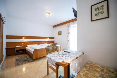 a hotel room with a bed and a table and a bed at Apartments Zilli in Laion