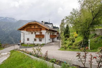 a house on a hill with a road next to it at Apartments Zilli in Laion