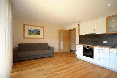 a living room with a couch in a kitchen at Jausenstation Moar in Funes