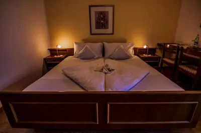 a large bed with white sheets and pillows on it at Hotel Gasthof WASTL in Appiano sulla Strada del Vino