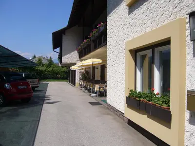 a building with chairs and umbrellas on a street at Hotel Gasthof WASTL in Appiano sulla Strada del Vino