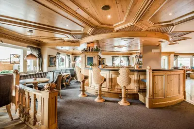 a bar in a restaurant with wooden ceilings at Hotel Fürstenhof in Schenna