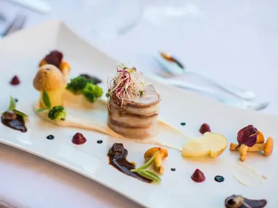 a white plate with food on a table at Hotel Fürstenhof in Schenna