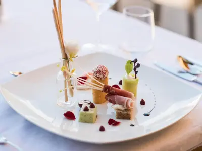 a white plate with desserts on a table at Hotel Fürstenhof in Schenna