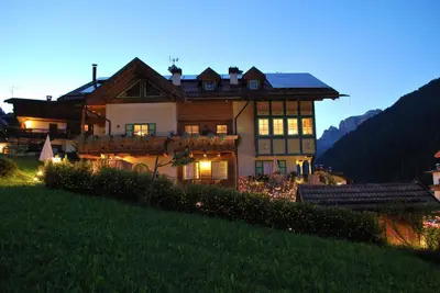 a large house sitting on top of a hill at Garnì Val de Costa in Canazei
