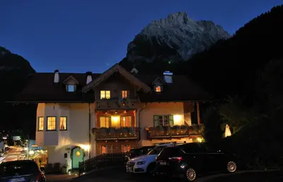 a house with cars parked in front of it at night at Garnì Val de Costa in Canazei