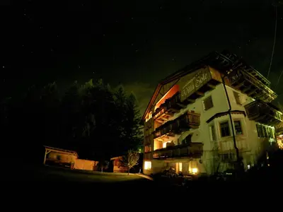 a lit up building at night in the dark at Villa Sole in San Vigilio Di Marebbe