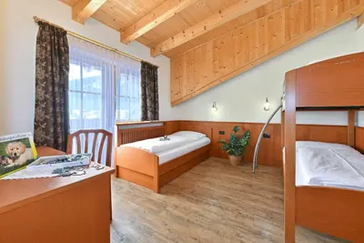 a bedroom with a bunk bed and a desk at Villa Sole in San Vigilio Di Marebbe