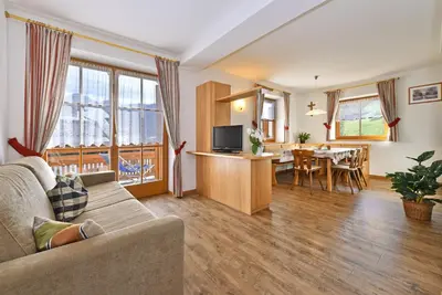 a living room with a couch and a dining room at Villa Sole in San Vigilio Di Marebbe