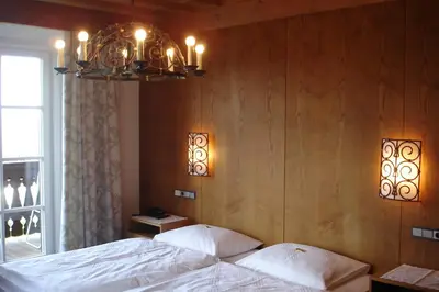 a bedroom with a bed and a chandelier at Hotel Latemar in Soprabolzano