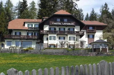 a building with a fence in front of it at Hotel Latemar in Soprabolzano