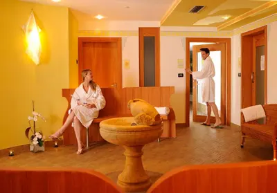 a woman sitting in a bathroom with a man in a bath room at Residence Kristall- Fiemme Holidays in Predazzo