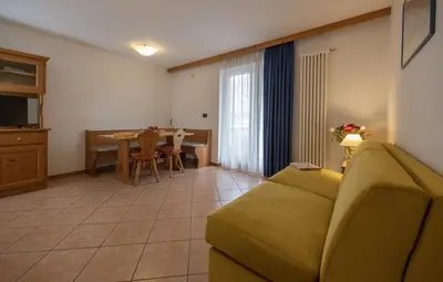 a living room with a couch and a table at Residence Kristall- Fiemme Holidays in Predazzo
