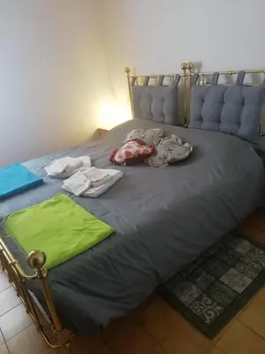 a bed with clothes and towels on it at Casa a piè di pista in Tesero
