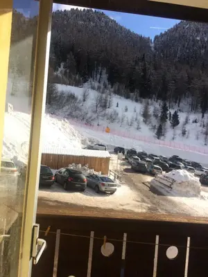 a view of a parking lot with cars in the snow at Casa a piè di pista in Tesero