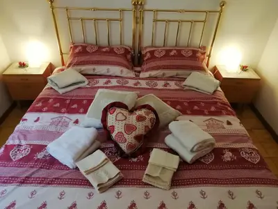 a bed with towels and a heart on it at Casa a piè di pista in Tesero