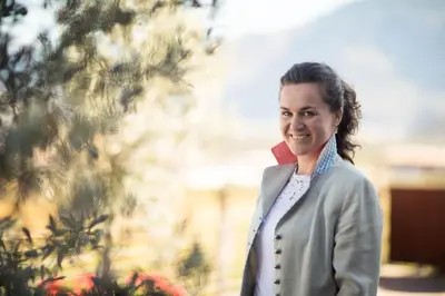 a woman in a suit standing in front of a tree at Weingut Donà in Appiano sulla Strada del Vino
