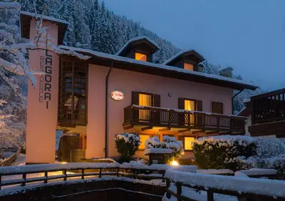 a hotel in the snow at night at Residence Lagorai - Fiemme Holidays in Predazzo