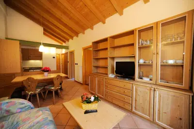a living room with a kitchen and a dining room at Residence Lagorai - Fiemme Holidays in Predazzo
