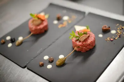 a black plate with some food on a table at Hotel Hanswirt in Rablà
