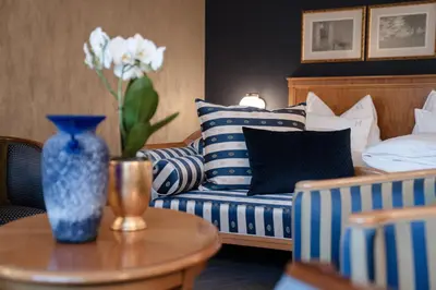 a living room with blue and white pillows and a couch at Hotel Hanswirt in Rablà