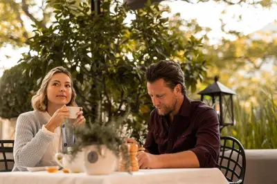 a man and woman sitting at a table drinking coffee at Hotel Hanswirt in Rablà